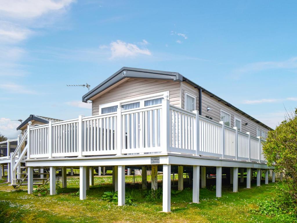 a large wooden house with a white deck at Apple Grove 110 - Ukc9393 in Exmouth