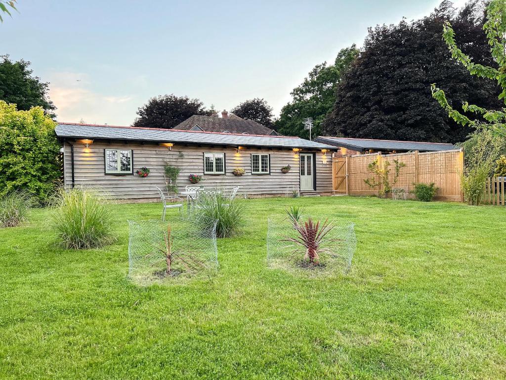 a house with a yard with plants in front of it at Snowdrop Lodge -Uk32959 in Molash