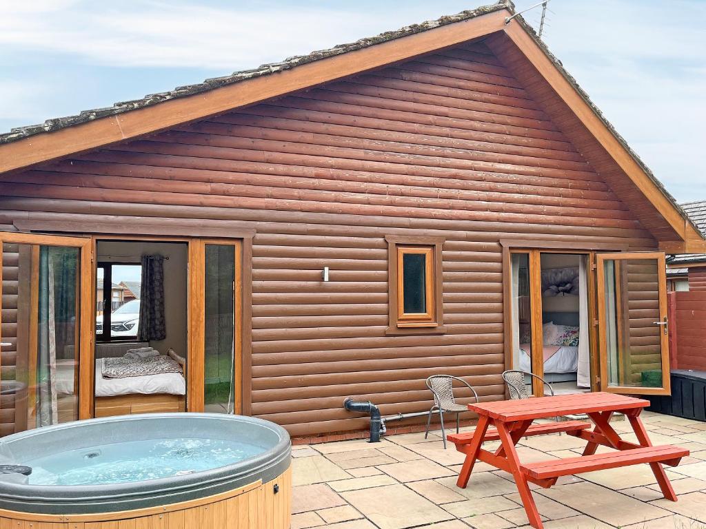 a house with a hot tub and a picnic table at Jasmine Lodge in Garton