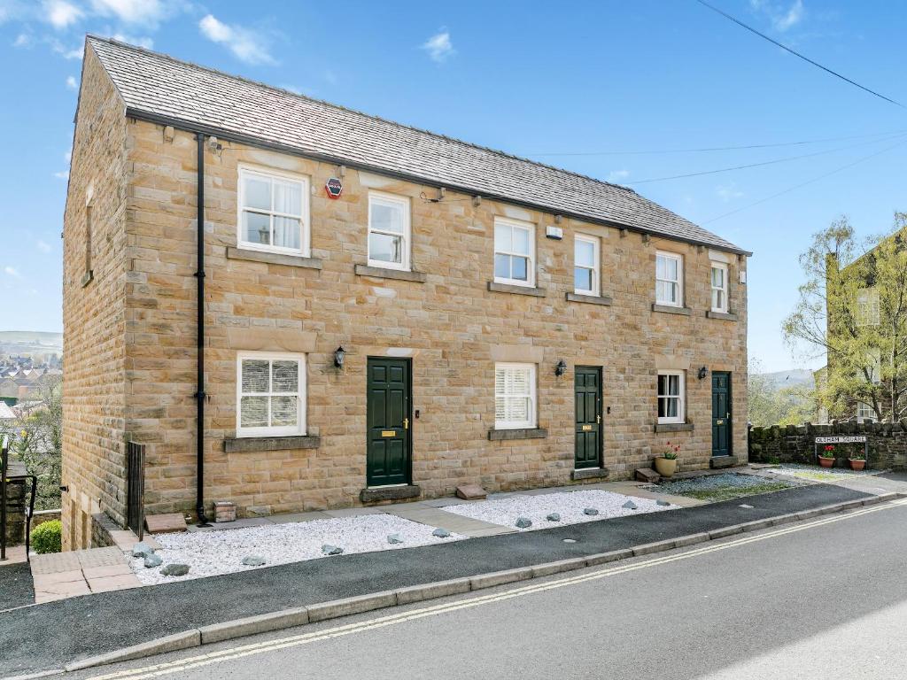 a brick house on the side of a street at Anne's Cottage in Strines