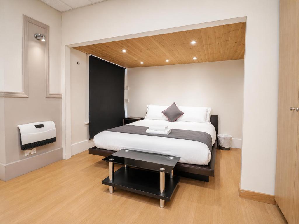 a bedroom with a bed and a table in it at Highfield Hotel Blackpool in Blackpool