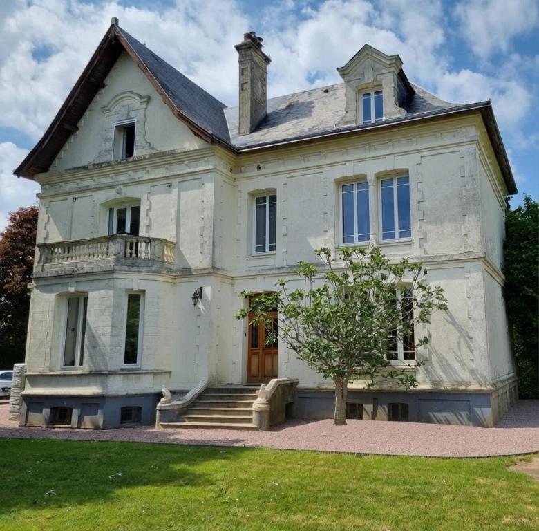 an old white house with a tree in front of it at La Casa des Frangins in Saint-Romain-de-Colbosc