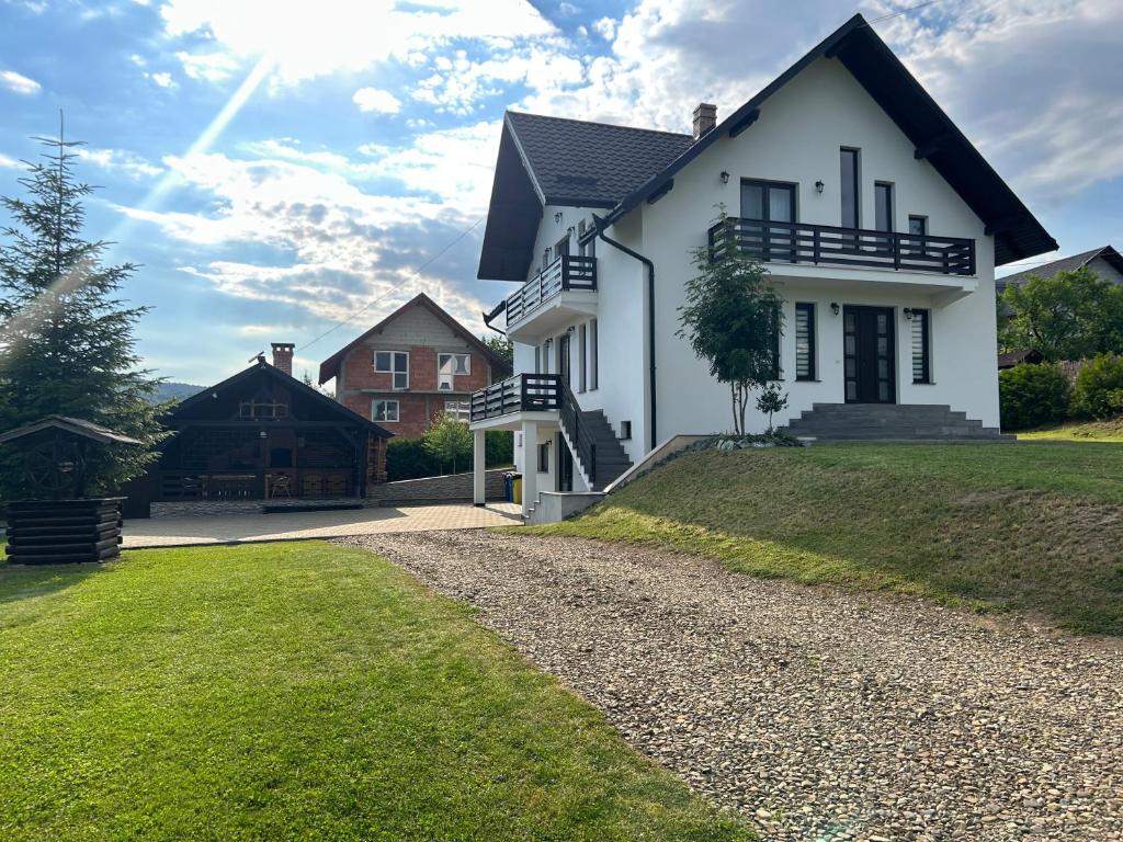 a white house with a gravel driveway at Cacica Holiday in Cacica