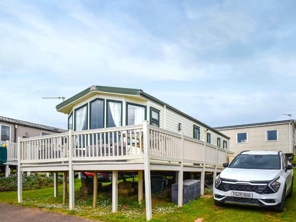 a house with a car parked in front of it at Apple Grove 24 in Exmouth