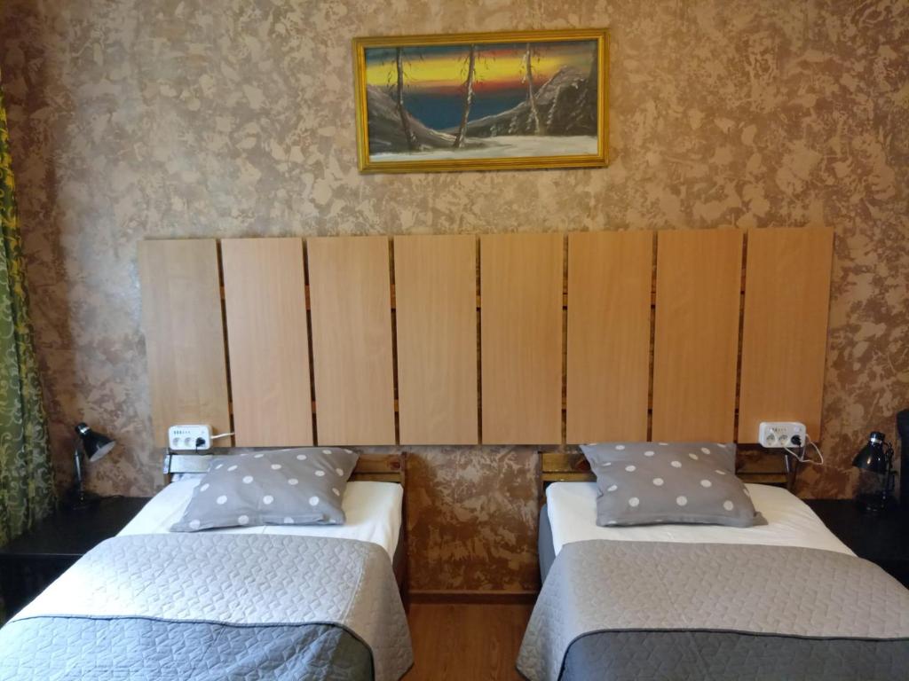 two beds in a room with a picture on the wall at Apartment by the park in Imatra