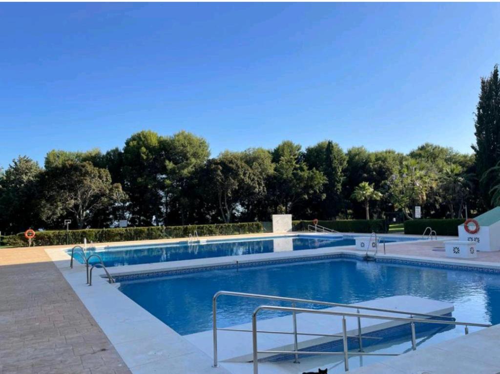 a large swimming pool with blue water at SWEET HOME BENALMADENA Estudio para NO FUMADORES con vistas al mar y excelente conexion wifi NON SMOKING studio with sea views and excellent WiFi Enjoy plenty of morning sun in Benalmádena