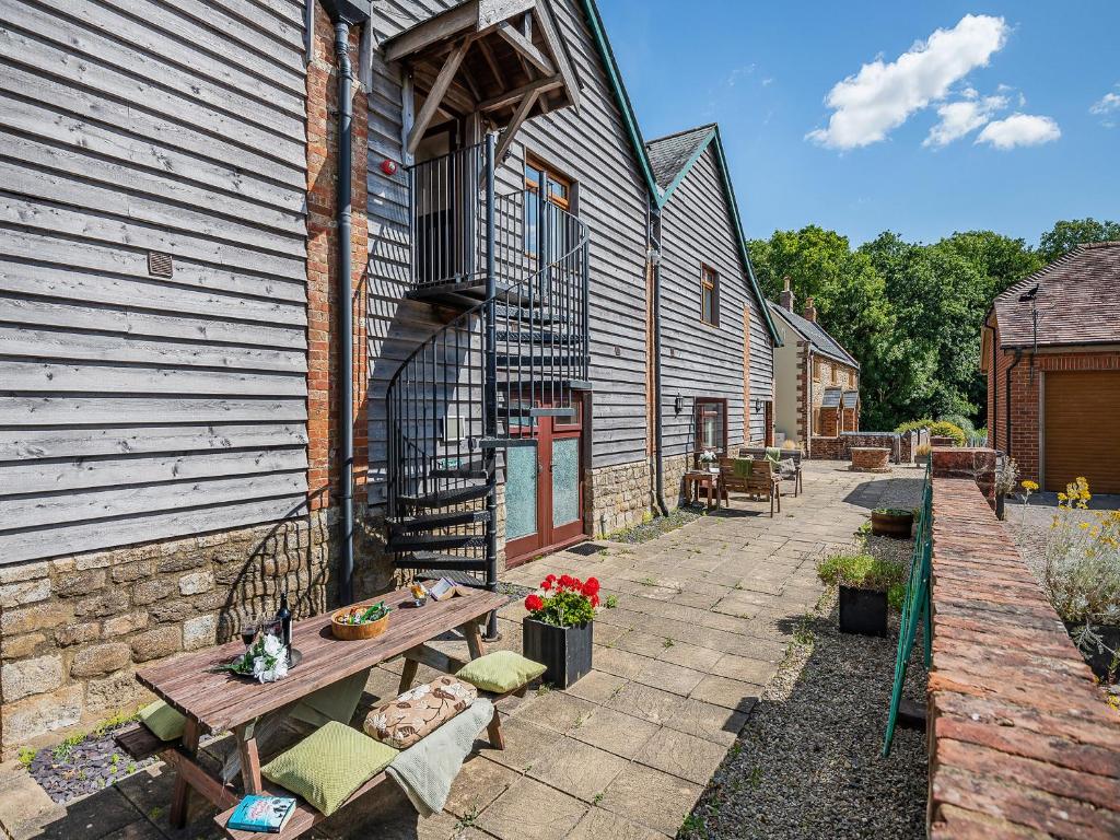 a building with a picnic table next to a building at Hayloft - Uk49909 in Blandford Forum