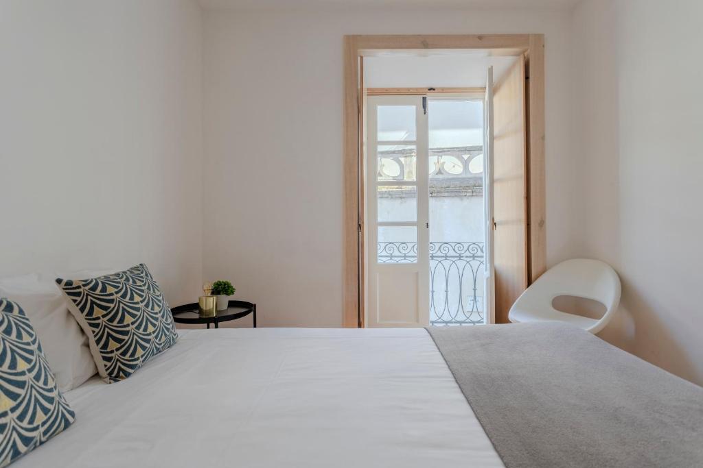 a bedroom with a white bed and a balcony at LOVELY Central Apartment 3Bdr by Vinum Apartment 1890 in Coimbra