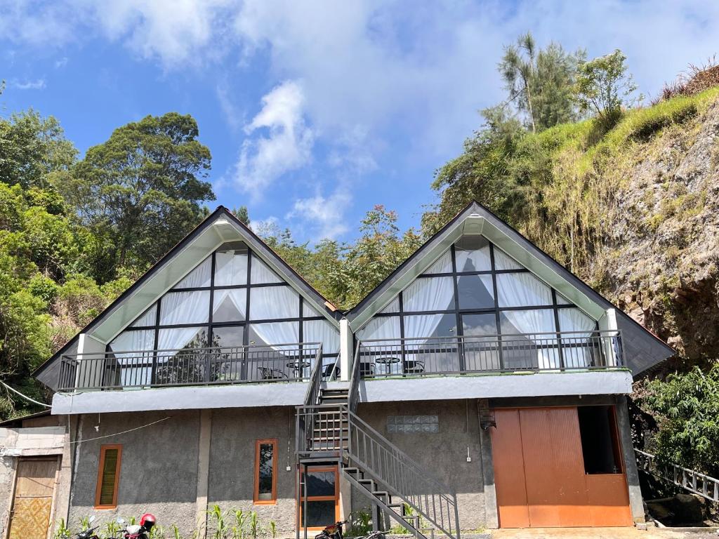 a house on a hill with a balcony at DIENG CAKRAWALA CABIN Tambi Syariah in Kejajar
