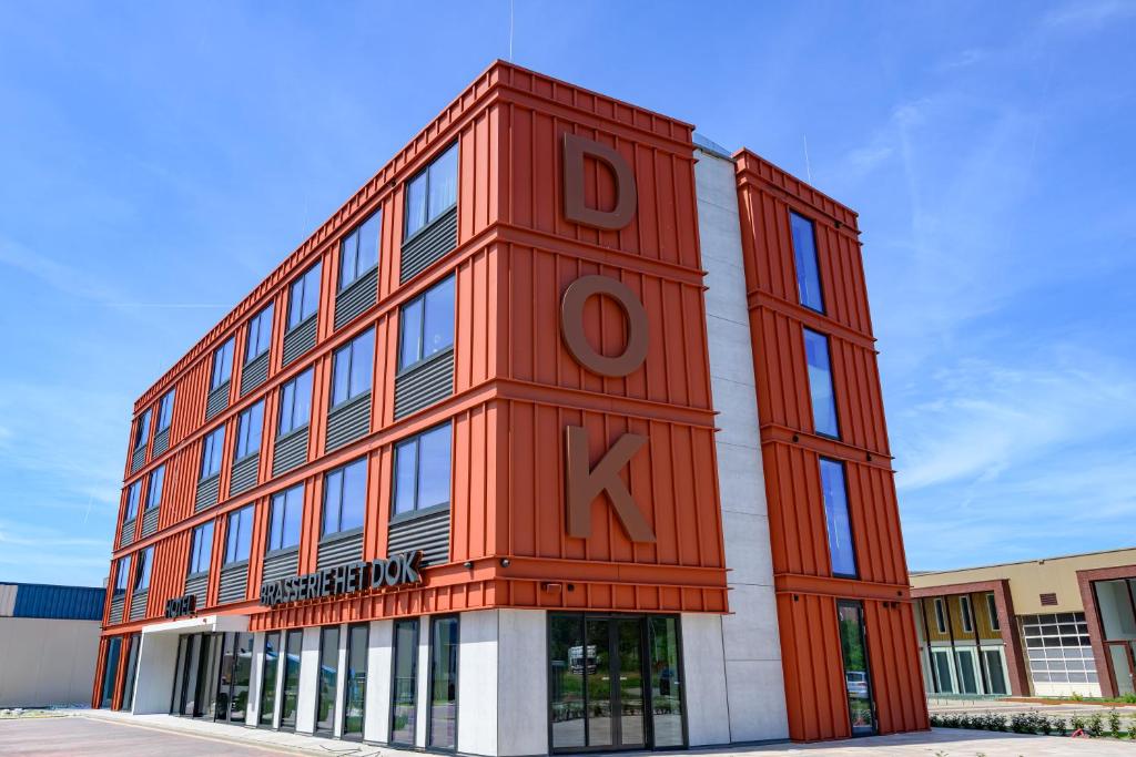 ein großes rotes Gebäude mit dem Wort Dox darauf in der Unterkunft Hotel het Dok in IJmuiden