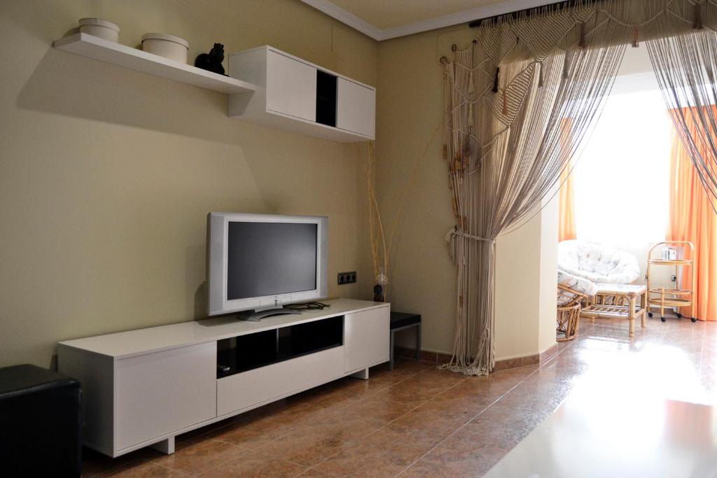 una sala de estar con TV en un armario blanco en Apartamento Plaza Mayor Trujillo, en Trujillo