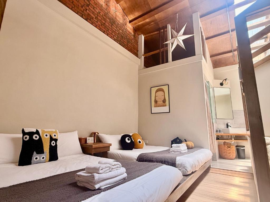 a bedroom with two beds with pillows at Eiko的樓仔厝-台南包棟民宿 in Ching-chung-san-ts'un