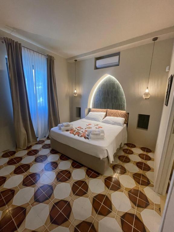 a bedroom with a bed and a tiled floor at Riad Gilda in Torre Canne
