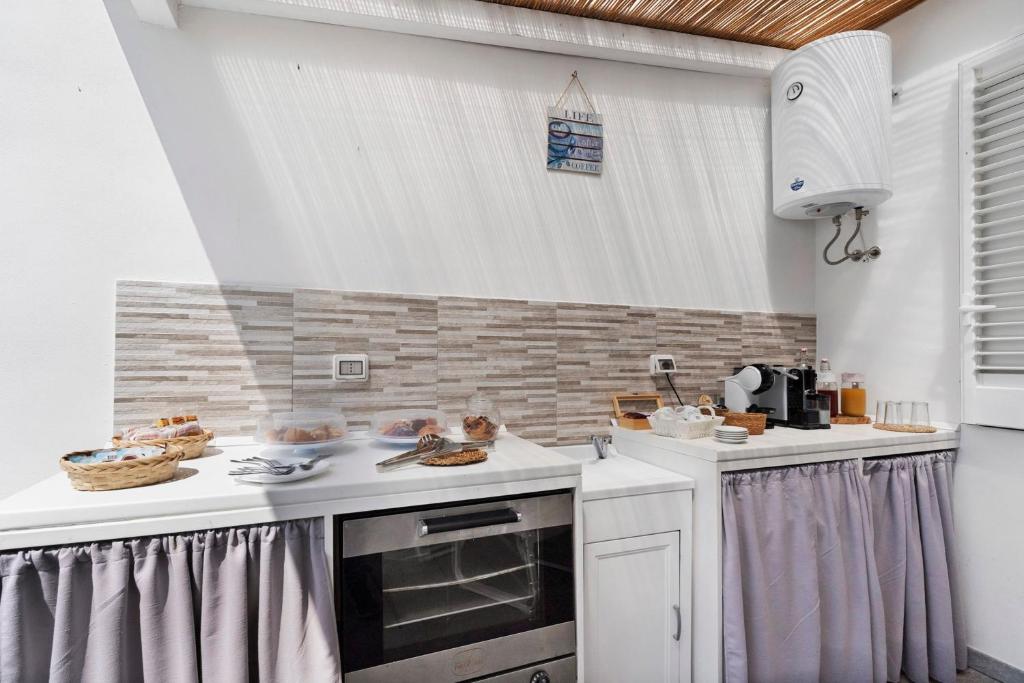 Il buffet della colazione sotto la pergola con dolci nei cestini, macchine del caffe e succhi