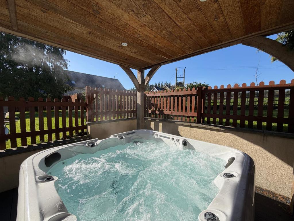 a hot tub on a patio with a wooden roof at Red Gables at Pudleston Court in Docklow