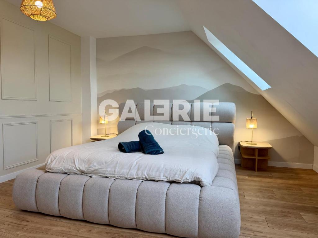 a bedroom with a bed with two blue pillows on it at GC - Les Oyats in Wissant