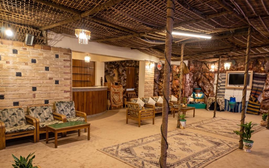 a living room with chairs and a couch and a tv at NJ Teachers Hotel in Luxor
