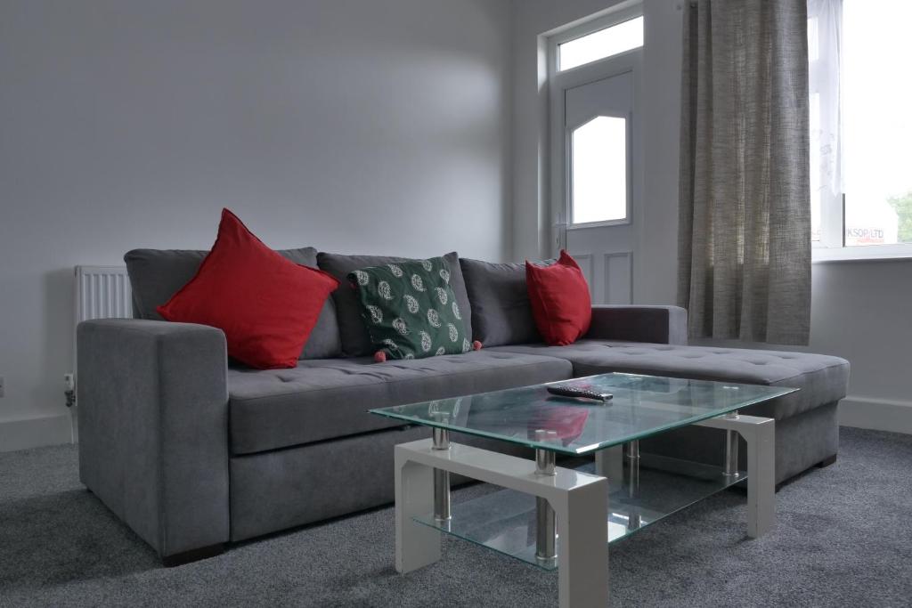a living room with a couch and a glass table at Modern 3BDR Home l Sleeps 5 l Free Parking l Close to Train station and Shops in Worksop