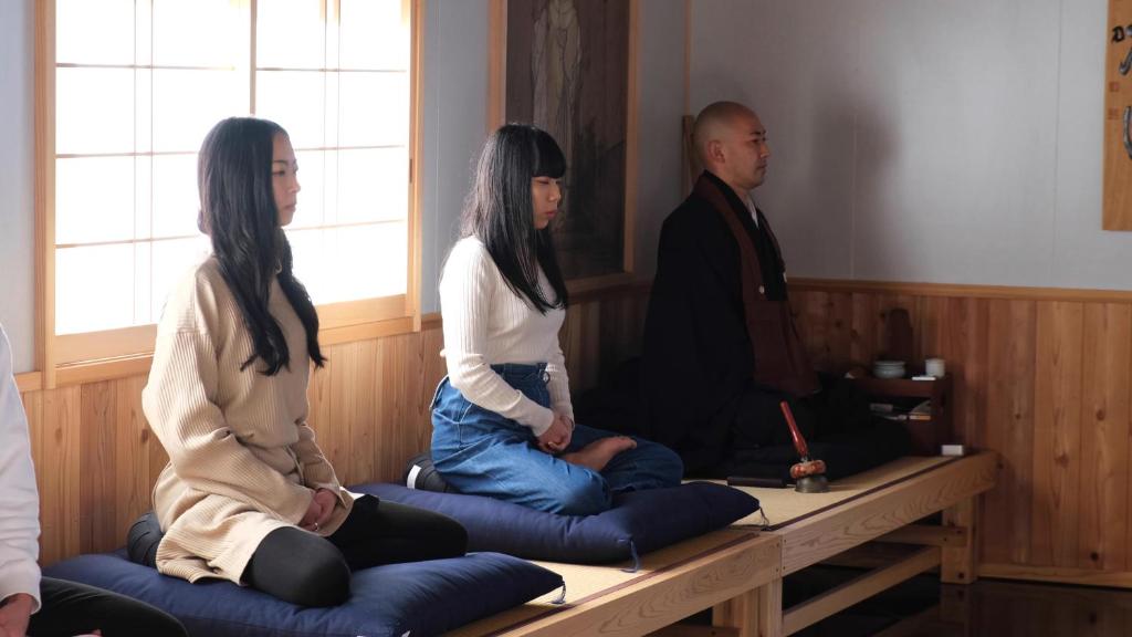 a man and two women sitting on a table at 宿坊 大泰寺 Temple Hotel Daitai-ji in Nachikatsuura