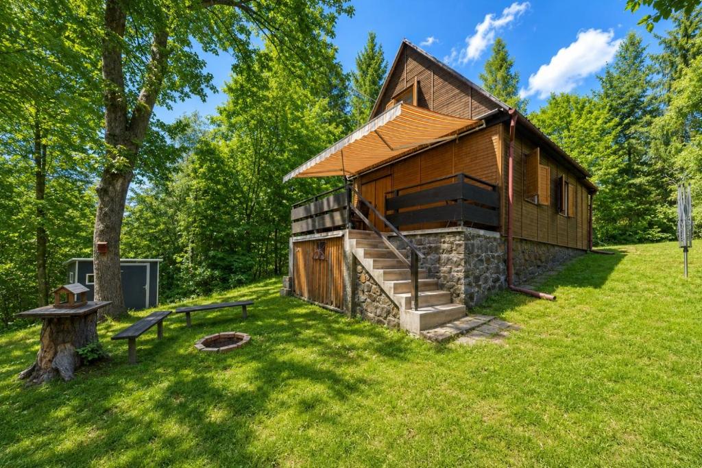 a log cabin in the middle of a green field at Chatka Kačka in Jedovnice