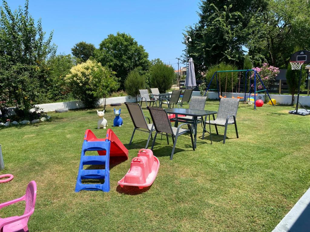 a backyard with a table and chairs and a playground at Harmony Studios & Apartments in Skala Potamias