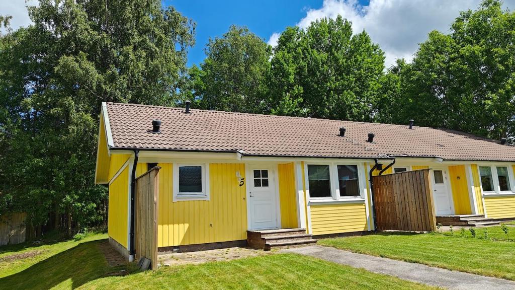 a yellow tiny house in a yard at Gårdsjö 5 in Gårdsjö