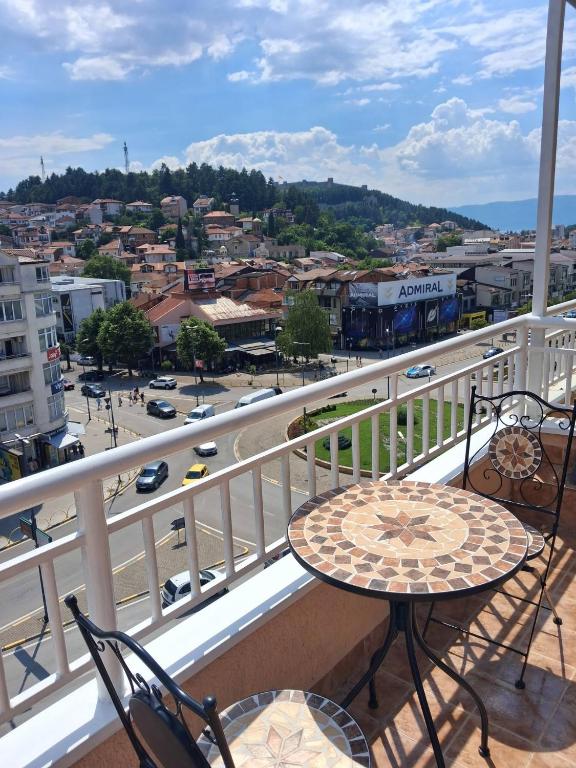 a balcony with a table and chairs and a city at Queen's Apartment Ohrid in Ohrid