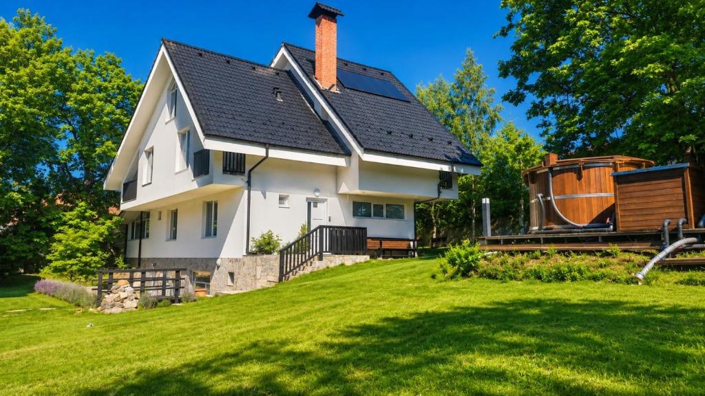 a white house with a black roof and a yard at Villa Eloris in Pismenovo