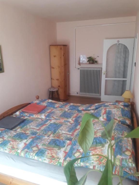 a bedroom with a bed with a quilt on it at Közös Nevező Vendegház in Keszthely
