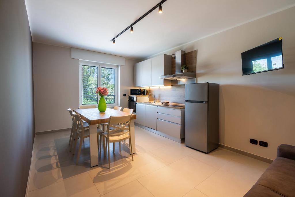 eine Küche mit Tisch, Stühlen und Kühlschrank in der Unterkunft Casa Luccon in Salionze