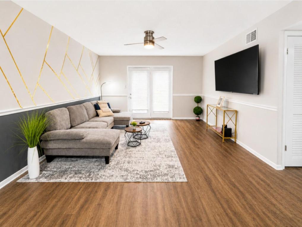 a living room with a couch and a flat screen tv at Maple n Main Hoover Modern 2BR Escape 2E in Hoover