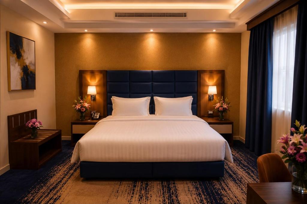 a hotel room with a large bed and two tables at Smart Gate Hotel Apartments سمارت غيت للشقق الفندقية in Jazan