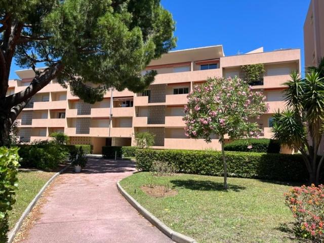 a large apartment building with a tree in front of it at 50 pas de l'Ô in Saint-Cyr-sur-Mer