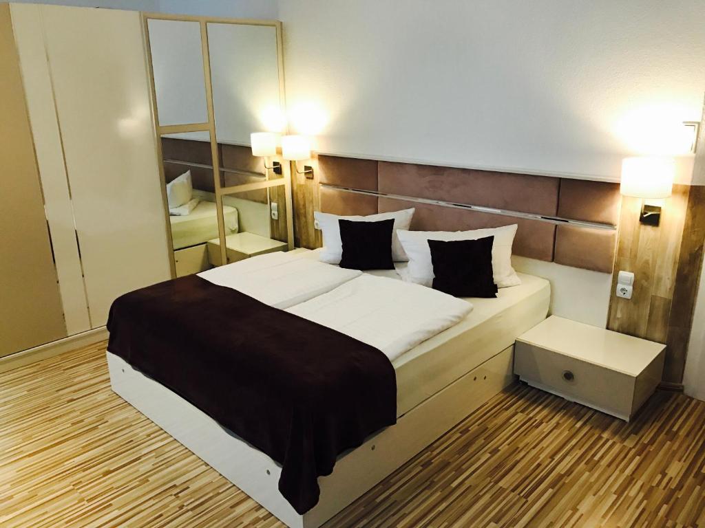 a bedroom with a large bed and a mirror at City Central Promenade in Bad Homburg vor der Höhe