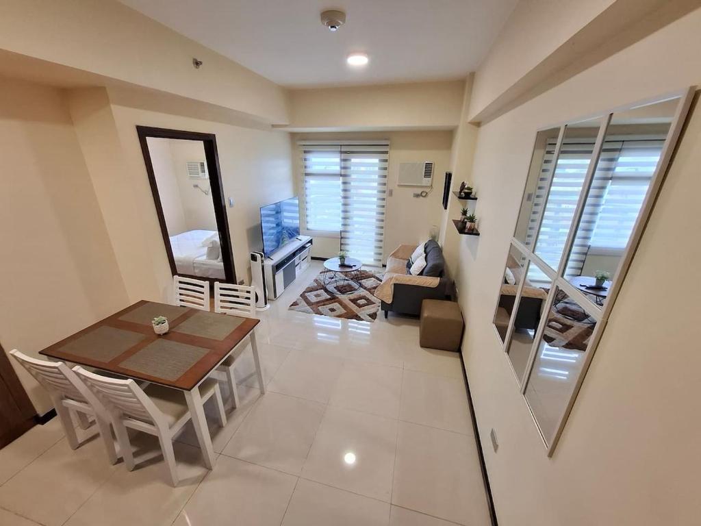 a living room with a table and a couch at Roomy 1BR Balcony-40sqm-4px-PET-Parking-MOA,PICC,WTC,CCP in Manila
