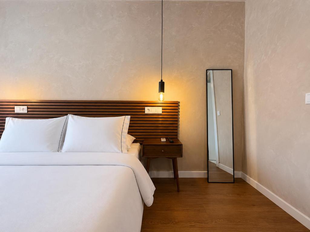 a bedroom with a bed and a night stand with a mirror at Apartments City Center • Collection by Perpetual Relax in Braga