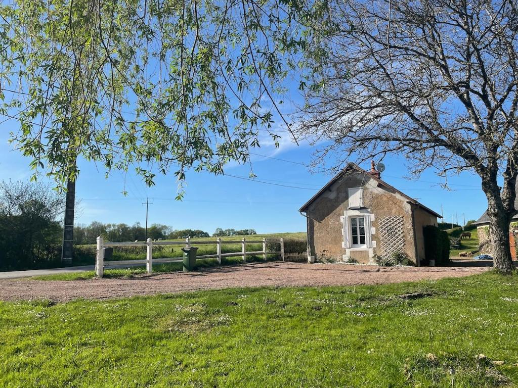 an old stone building next to a fence at La morvandelle in Limanton