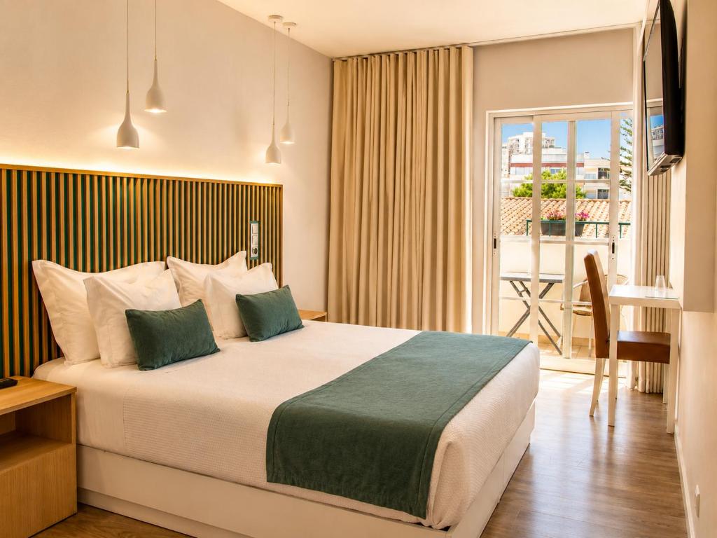 a hotel room with a bed and a balcony at Hotel Sol Algarve by Kavia in Faro