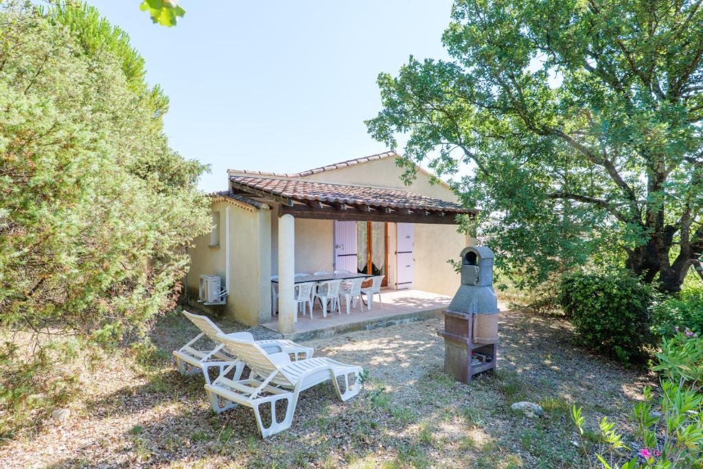 a cottage with a table and chairs in the yard at Le Chêne - La Fontinelle in Bessas