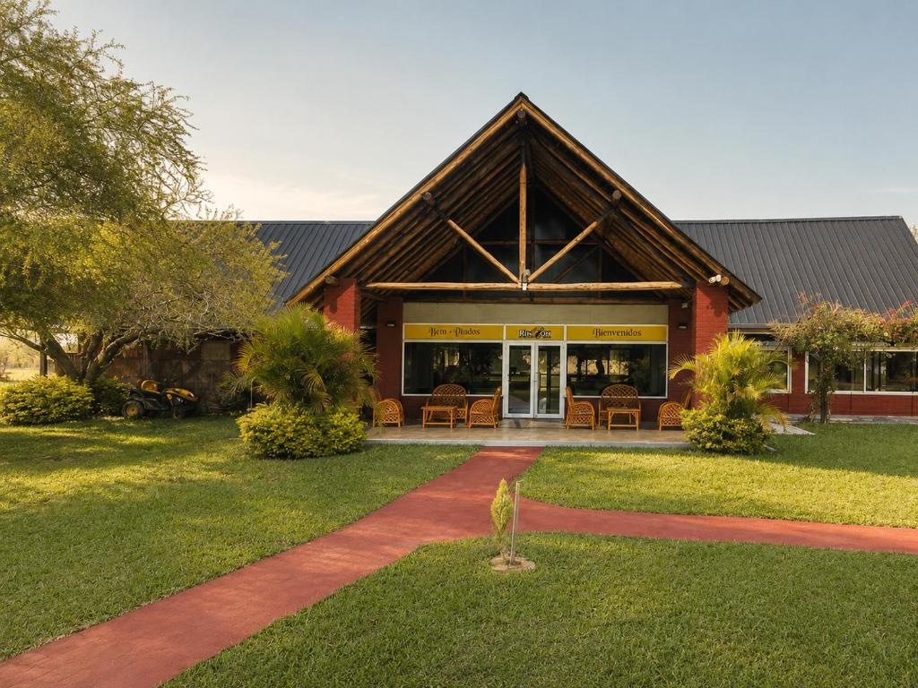 a large building with a porch and a patio at Rincon del Dorado Lodge in Goya