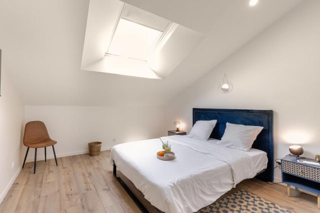 a bedroom with a bed with a blue headboard and a window at Suite Attrape-Rêves - jardin - 2p in Sainte-Geneviève-des-Bois