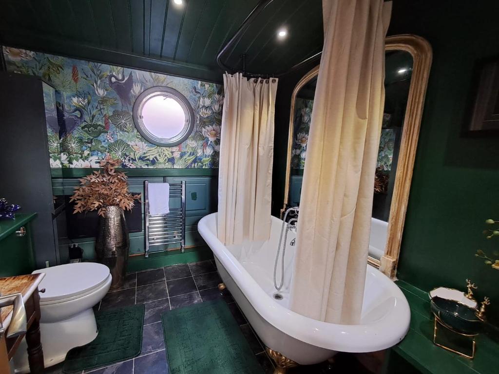 a green bathroom with a tub and a toilet at Selene Unique Luxury Houseboat Experience in Chertsey