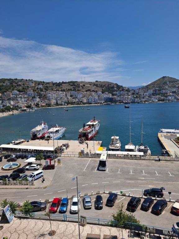 a parking lot with cars and boats in a harbor at Saranda porti in Sarandë