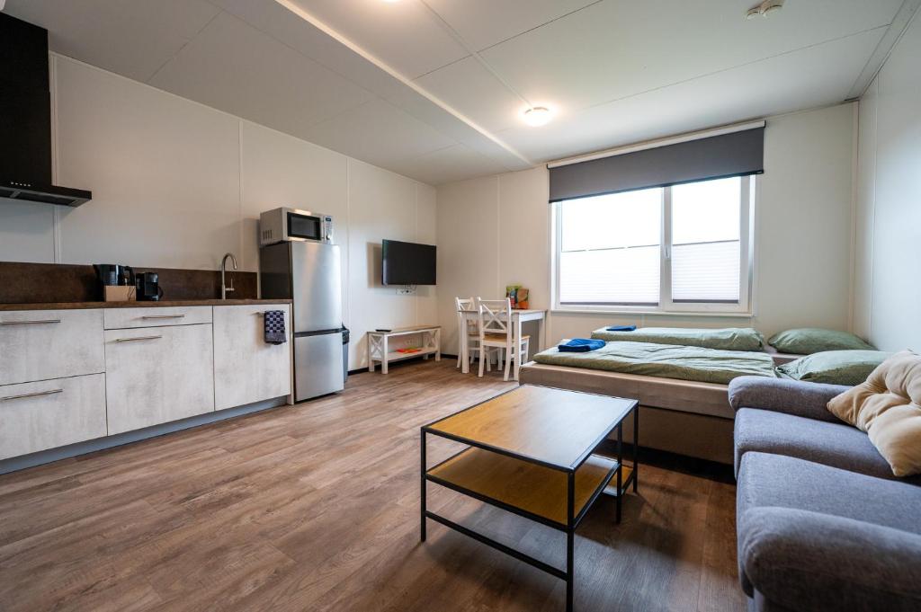a kitchen and a living room with a couch and a table at Work and Stay in Maasbree