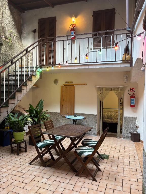a patio with a table and chairs and a staircase at Casa Raste in Lecco