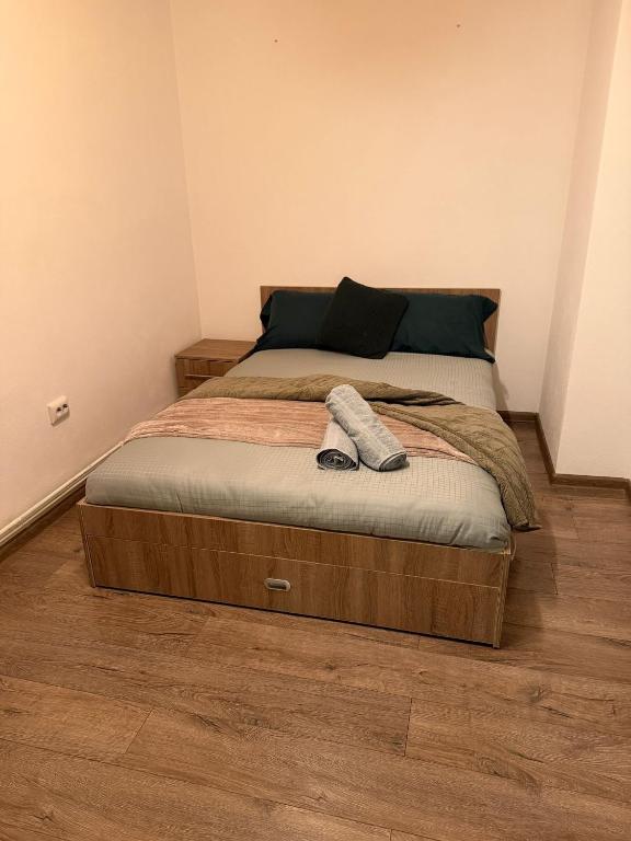a bed with a wooden frame in a bedroom at GZP Residece Lugoj 22 in Lugoj