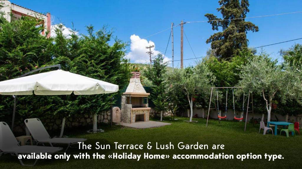 a garden with an umbrella and a playground at Villa Nektaria in Nikiana