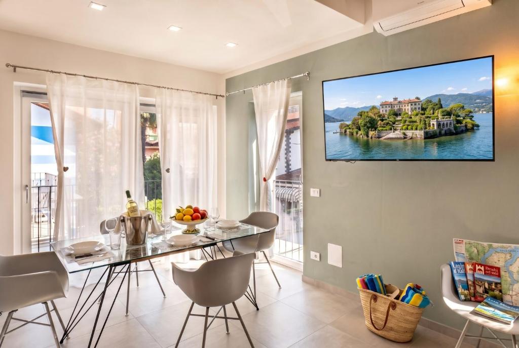 a dining room with a table and a tv on the wall at Casa Quadrifoglio - Borromeo in Intra