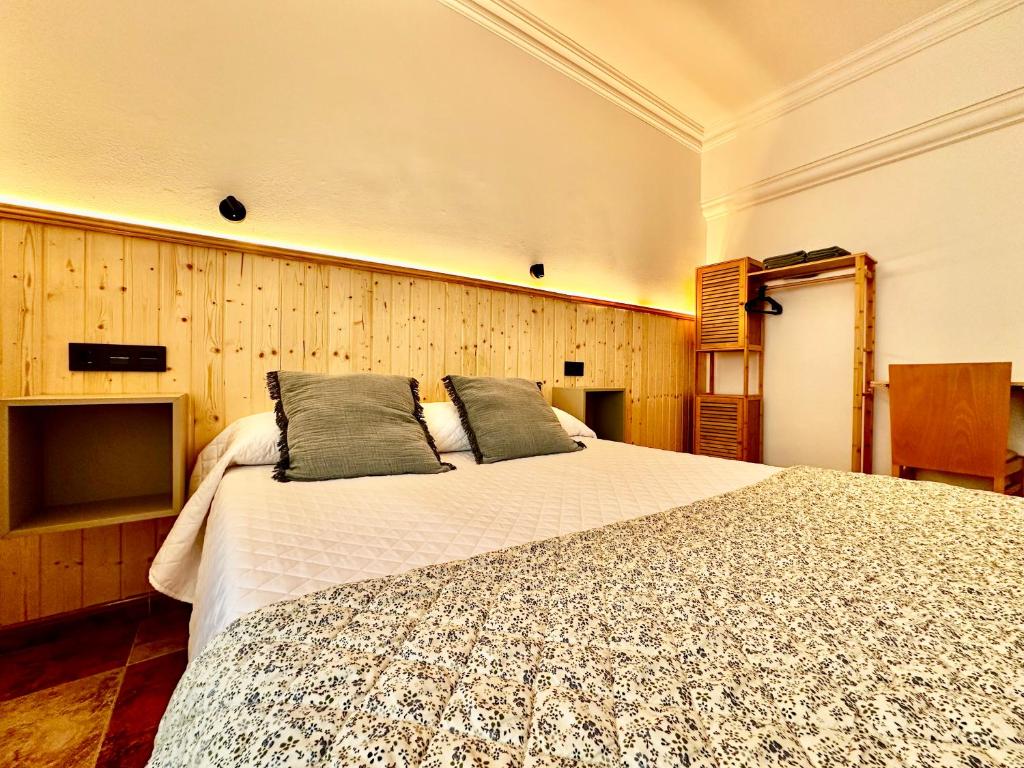 a bedroom with a large bed with two pillows on it at Hostal J&C in Olula del Río