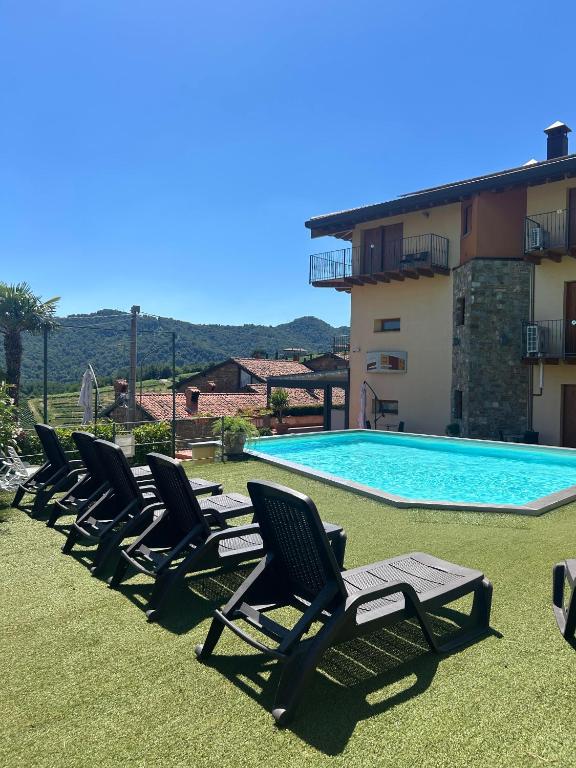 a row of lawn chairs next to a swimming pool at La Marina Resort in Pontida